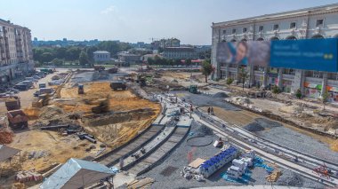 Yol inşaatında buldozerler ve kazıcılar üzerinde çalış. Alt tabakada ezilmiş taş. Destek faaliyetleri ve endüstriyel makineler. Tramvay raylarının yeniden inşası. Yukarıdan hava üstü görünümü