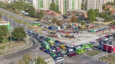 Tramvay raylarını yüklemek ve boşaltmak için bir yol şantiyesine yükleyici vinç. Kavşakta trafik sıkışıklığı