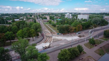 Tramvay rayları onarılan ve panoramik panoramik zaman ayarlı yol inşaatı. Beton, kavşağın ortasında mikserle çalışıyor. Taze betonu kaplıyor.