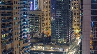 Dubai Marina havadan görünümden bir noktadan gece timelapse. Modern gökdelenler ve konut kuleleri parlayan windows ile aydınlatılmış. Köprüde trafik. Su yansımalar