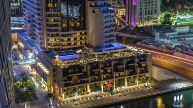 Lüks Dubai Yat Limanı kanal trafiği olan ve mesire Restoran gece timelapse ile üst görüntülemek üzerinden yukarıda ile ışıklandırılmış gökdelenler. Dubai, Birleşik Arap Emirlikleri