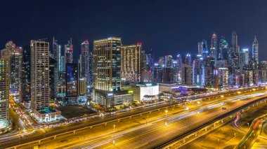 Dubai Yat Limanı timelapse fantastik çatı manzarası. Işıklandırılmış gökdelenler büyük bir şehrin gece, Birleşik Arap Emirlikleri. Havadan görünümden Jlt trafik ile Şeyh zayed yolu üzerinde