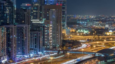 Dubai Yat Limanı timelapse fantastik çatı manzarası. Işıklandırılmış gökdelenler büyük bir şehrin gece, Birleşik Arap Emirlikleri. Hava Jlt görünümünden