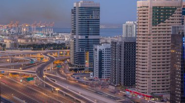 Dubai Yat Limanı gökdelenler hava üstten görünüm güneş doğmadan önce Jlt gelen Dubai gece gün timelapse, Birleşik Arap Emirlikleri için. Işıklı modern kuleleri ve kavşak ile Şeyh zayed yolu üzerinde trafik