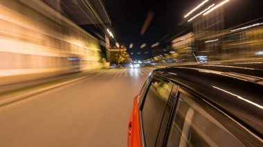 Hızlı arabanın yanından gelen bir saçmalık. Bir gece caddesinde hızla ilerliyor. Işıklar yüksek hızda arabaya yansıyor. Modern bir şehrin hızlı ritmi. Bulanık hareket