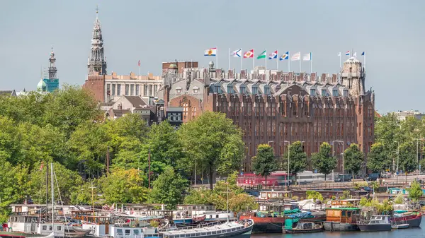 Amsterdam ufuk çizgisi Oosterdok limanındaki teknelerle Scheepvaarthuis hava zaman çizelgesi. Amsterdam Centraal İstasyonu yakınlarındaki geleneksel Hollanda mimarisi. Amsterdam, Hollanda