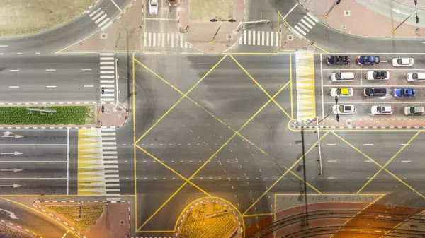 Bir büyük şehir gece timelapse bir yol kavşak hava üstten görünüm. Arabalar ve tramvay hattı ile UAE Dubai Yat Limanı bölgesinin kentsel peyzaj.