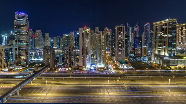 Dubai Yat Limanı timelapse fantastik çatı manzarası. Işıklandırılmış gökdelenler büyük bir şehrin gece, Birleşik Arap Emirlikleri. Hava Jlt görünümünden