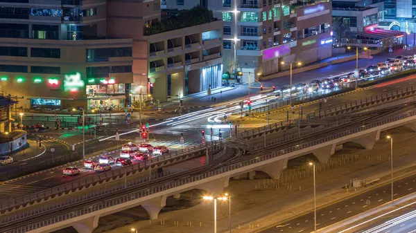 Bir büyük şehir gece timelapse bir yol kavşak hava görünümünü. Arabalar ve tramvay ile UAE Dubai Yat Limanı bölgesinin kentsel peyzaj