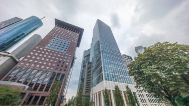 Hiperlapse, Frankfurt 'un Innenstadt bölgesindeki cam gökdelenlere bakıyor. Yüksek modern mimari, bulutları ufuk çizgisi boyunca yansıtır. Frankfurt am Main, Almanya.