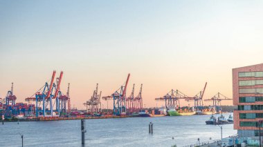 Gün batımında Hamburg kargo limanının hava tarifesi Elbe Nehri 'nde konteynır terminalleri, vinçler ve kargo gemileri sergileniyor. Tekneler ve gemiler geçiyor ve dinamik bir deniz manzarası yaratıyorlar. Almanya