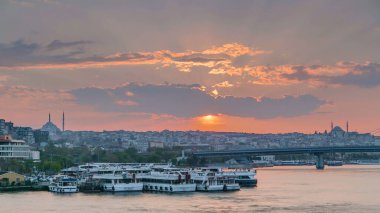 İstanbul 'un ufuk çizgisi İstanbul' da, günbatımında Boğaziçi ve Altın Boynuz 'daki tekne istasyonu yakınlarında çok sayıda yolcu feribotu bulunuyor. Arka planda cami ve köprü, bahar akşamında suyun yansımasıyla