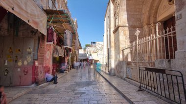 Kudüs 'ün eski kenti Kudüs' teki Kutsal Mezar 'ın yanındaki renkli çarşaf. İsrail zaman atlaması. Bu pazarda bir sürü insan geçiyor.