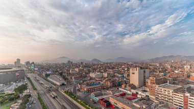 Via Expresa otoyolu ve Peru Ulusal Stadyumu yakınlarındaki trafikli metropol panoramik manzarası. Evler ve şehrin arka planında dağlar olan silueti. Lima, Peru