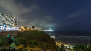 Villena Köprüsü 'nde trafik ve kısmi şehir manzarası var. Günbekten geceye geçiş zamanı, Lima, Peru. Aşk parkından aydınlık kıyı şeridi manzarası