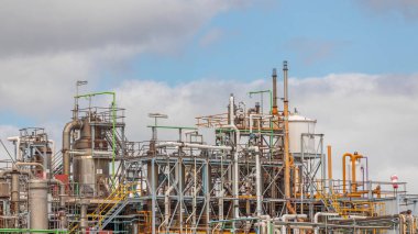 Damıtma Sütunları ve hidrojen bitkisinin çalışma ekipmanları. Arka planda bulutlar var. Bir çok boru ve tank gökyüzüne karşı endüstriyel fabrika