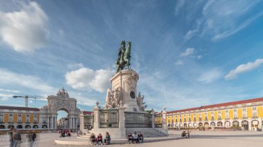 Praca do Comercio (Ticaret Meydanı). Kral 1. Jose 'nin heykeli hiperhızlandırılmış. Kral sembolik olarak yoluna çıkan yılanları eziyor. Bulutlu bir gökyüzü ve arka planda renkli evler. Lizbon, Portekiz.
