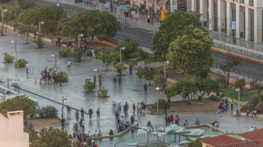 Lizbon, Portekiz 'deki Martim Moniz Meydanı' nın hava görüntüsü. İnsanlar fıskiyenin yanında oturup yürüyorlar. Günbatımında tarihi mimari tarafından çerçevelenen hareketli bir kültür ve çeşitlilik merkezi.