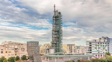 Lizbon 'un Milletler Parkı' nda modern bölgede sarmal rampası olan eski çelik rafineri kulesinin hızlandırılmış zamanlaması. Arka planda trafik ve bulutlu bir gökyüzü var. Apartman binaları var. Portekiz