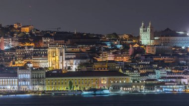 Lizbon 'un aydınlık tarihi merkezi Terreiro do Paco ve Tagus Nehri' nin alacakaranlıktaki hava zaman çizelgesinde tarihi binalar, feribot terminali ve Portekiz 'deki Se de Lisboa Katedrali yer alıyor.