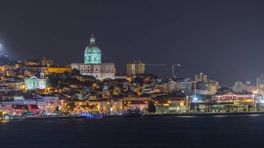 Lizbon 'un tarihi merkezinin, aydınlatılmış Ulusal Panteon, tarihi binalar ve yüzen gemilerle birlikte Portekiz, Tagus Nehri' ndeki feribot terminalinin uçuş zamanı.
