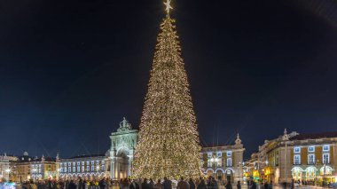 Lizbon 'daki ticaret meydanı Noel' den geceye kadar aydınlandı. Geçiş süreci aşırı hızlandı. Yükselen bir ağaç ve kutlanan kalabalıkla. Festival atmosferi ve tarihi mimarinin zamanlaması