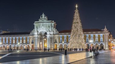 Lizbon 'daki ticaret meydanı, Noel' de yüksek bir ağaç ve geceleri kemerle aydınlandı. Dekorasyon ve tarihi mimarinin yer aldığı şenlikli atmosferin zamanlaması