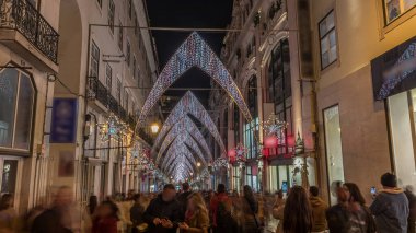 Lizbon şehir merkezindeki Chiado Carmo sokağındaki Noel ışıkları ve dekorasyonları gece aşırı hızlandı. İnsanlar aydınlanmış kemerlerin altında yürürler. Portekiz 'de festival dekorlu tatil atmosferi