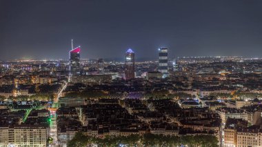Geceleri Fourviere Hill 'den gökdelenlerle Lyon' un panoramik hava manzarası. Ufuk çizgisinde Rhone Nehri ve ikonik kent simgeleri yer alıyor. Evler çatılar ve caddelerde trafik