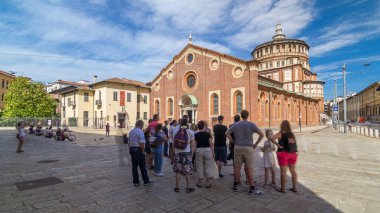 Santa Maria delle Grazie timelapse hyperlapse mavi bulutlu gökyüzü ile. Milan, İtalya. Bir bankta oturan insanlar. Bu kilise ve bitişik Dominik manastır 15th yüzyıl boyunca inşa edildi.