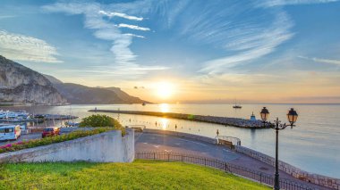 Beaulieu sur mer, Fransa 'dan deniz ve manzaranın gündoğumu panoramik görüntüsü. Tekneler ve yatlar ön planda. Sudaki yansımalar.