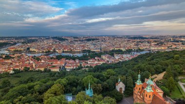 Çek Cumhuriyeti 'ndeki Petrin Gözlem Kulesi' nden Prag 'a harika bir zaman çizelgesi. Gün batımından önce yeşil ağaçlar ve mavi bulutlu gökyüzü