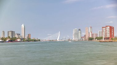 Hollanda, Rotterdam 'daki Maas Nehri' ni kapsayan Kuğu adlı Erasmus Köprüsü zaman çizelgesi panoraması. Hollanda 'nın en büyük kablo destekli baskülü köprüsü gökdelenleri, tekneleri ve bulutlu mavi gökyüzü