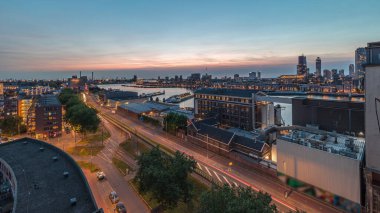 Rotterdam 'daki Katendrecht ve Maas Nehri gibi demirli gemilerle Maashaven' daki hava panoramik görüntüsü günden geceye geçiş zamanı. Eski fabrika yakınlarındaki trafik ofis ve etkinlik alanına dönüştü