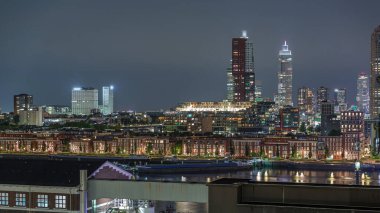 Hollanda Rotterdam 'daki Katendrecht Yarımadası ve Maashaven Limanı' nın panoramik zaman çizelgesi. Şehir silüeti, aydınlık modern gökdelenler ve liman evleri olan eski fabrikalar.