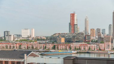 Rotterdam, Hollanda 'daki Katendrecht Yarımadası ve Maashaven Limanı' nın panoramik zaman çizelgesi. Sabah şehir silueti, modern gökdelenler ve Hollanda kıyısı evleri olan eski fabrikalar.