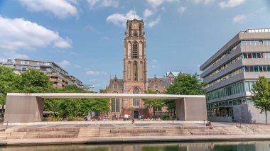 Laurenskerk 'in (Saint Lawrence Kilisesi) Grotekerkplein, Rotterdam' daki hiperlapesi. İnsanlar mavi bulutlu gökyüzünün altında çimlerde dinleniyorlar. Kanal merdivenlerinin yanında saati olan tarihi çan kulesi. Hollanda