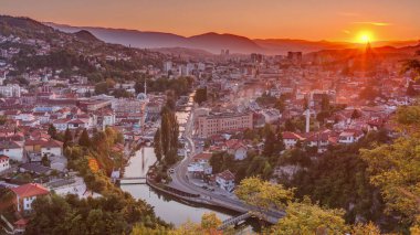 Saraybosna 'nın en popüler panoramik noktasından nehrin aktığı gün batımı manzarası. Sarı Kale (Zuta Tabija) yakınlarındaki yol, Vratnik