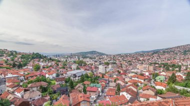 Saraybosna istasyonundan dağlara, Bosna-Hersek 'e giden teleferikli bir panorama. Kırmızı çatılı evler