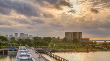 Marina Barrage 'da güzel bir gün doğumu zamanı. Turuncu gökyüzü ve güneş ışınlı bulutlar. Singapur 'un 15. su deposu ve şehrin göbeğindeki ilk su deposudur..