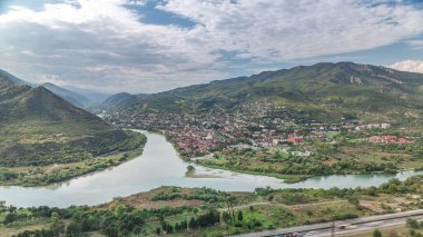 Kura ya da Mtkvari ve Aragvi nehirlerinin tek bir zaman diliminde birleşmesinin havadan görüntüsü. Gürcistan 'ın eski başkenti Mtskheta (sağda). Şehrin güzel manzarası, Georgia. Bulutlar geçip gidiyor