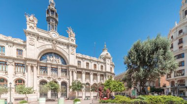 Belediye Binası Meydanı 'nda (Plaza del Ayuntamiento Meydanı) tarihi Posta Ofisi' ni (Palau de les Comunicacions) gösteren panorama. Süslü cephe, trafik ve İspanya şehir merkezinde mavi bir gökyüzü..