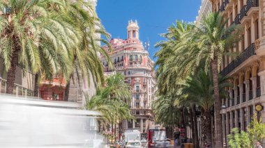 Valencia Bankası 'nın tarihi tarihi merkezi Valencia, İspanya' da. Göz kamaştırıcı bir mimari, palmiye kaplı bir sokak ve parlak mavi gökyüzü altında yoğun bir trafik. Şehir finans bölgesi sahnesi