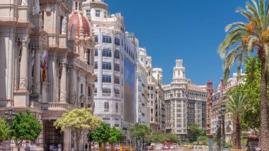 Valencia Belediye Sarayı (Ajuntament de Valencia) Plaza de Ayuntamiento 'da zaman aşımı. Mavi gökyüzünün altındaki tarihi bina giriş kulesi. İspanya 'nın ana meydanında gezinen insanlar