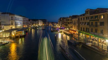 Grand Canal in Venice, Italy day to night transition timelapse. Panoramic view on gondolas and city lights from Rialto Bridge. Beautiful and romantic Italian city on water.