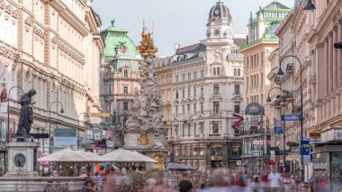 Graben Caddesi 'nde Viyana' nın ana caddesinde birçok dükkan ve restoran bulunan insanlar yürüyor. Pestsaule adındaki sütun, son büyük salgın hastalığın sona ermesinden sonra açıldı.
