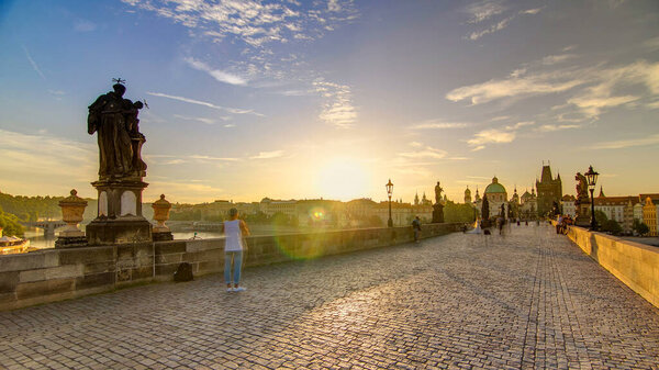 Charles Bridge in Prague during the sunrise panoramic timelapse, Bohemia, Czech Republic. Cloudy sky at morning