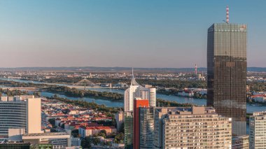 Donau City gökdelenleri, tarihi binaları ve Avusturya 'da nehir kenarındaki gezinti saatleriyle Viyana' nın panoramik manzarası. Tuna Kulesi 'nden gün batımından önce akşam silüeti