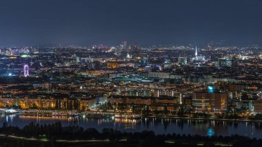 Viyana üzerinde gökdelenler, tarihi binalar ve Avusturya 'da nehir kenarında bir gece gezintisi ile hava panoramik manzarası. Tuna Kulesi perspektifinden aydınlatılmış gökyüzü
