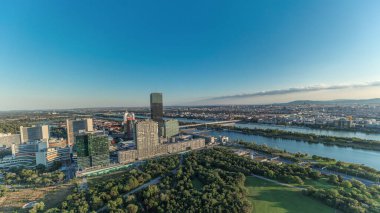 Donau City gökdelenleri, tarihi binaları ve Avusturya 'da nehir kenarındaki gezinti saatleriyle Viyana' nın panoramik manzarası. Tuna Kulesi 'nden gün batımından önce akşam silüeti